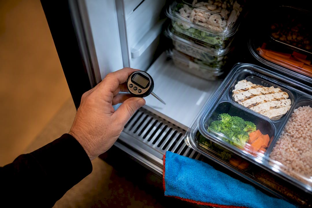 Operator checking refrigerated market temperature